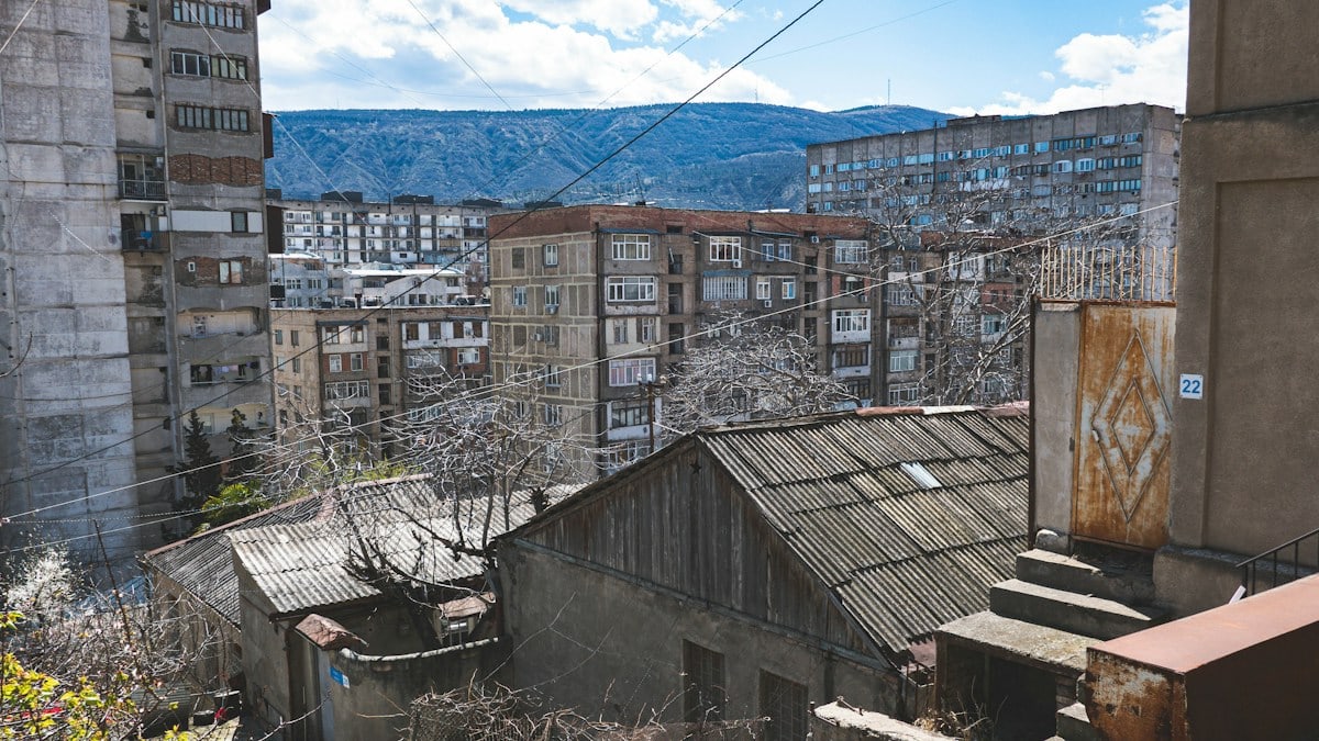A view of a city with buildings and mountains in the background
