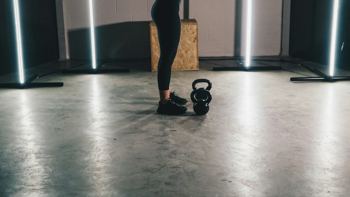 woman in black tank top and black leggings standing on white floor